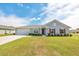 Charming single-story home with a well-manicured lawn, attached garage, and inviting red door at 3418 Sw 155Th Pl, Ocala, FL 34473