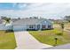 Charming single-story home with a well-manicured lawn, attached garage, and inviting red door at 3418 Sw 155Th Pl, Ocala, FL 34473
