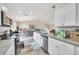Open kitchen featuring white cabinets, stainless steel appliances, and an eat-in area at 3418 Sw 155Th Pl, Ocala, FL 34473