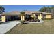Nice yellow single-Gathering home with an open garage, lush landscaping, and a spacious driveway at 360 Marion Oaks Golf Way, Ocala, FL 34473
