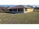 Rear exterior view of house showing expansive lawn, patio, and landscaping at 360 Marion Oaks Golf Way, Ocala, FL 34473