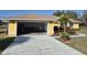 Home exterior highlighting a two-car garage and mature landscaping at 360 Marion Oaks Golf Way, Ocala, FL 34473