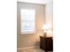 Bedroom showcasing a side table with lamp next to a bright window covered by blinds at 3947 Nw 46Th Ter, Ocala, FL 34482