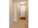 Neutral hallway with tiled floor leading to a door, enhanced by a patterned area rug at 3947 Nw 46Th Ter, Ocala, FL 34482