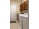 A laundry room features a sink, wood cabinets and modern washer and dryer units at 3947 Nw 46Th Ter, Ocala, FL 34482