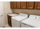 A laundry room features a sink, wood cabinets and modern washer and dryer units at 3947 Nw 46Th Ter, Ocala, FL 34482