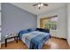 Serene bedroom showcasing a calming blue accent wall, wood-look floors, and a bright window, for relaxation at 4897 Cypress Wood Dr # 6313, Orlando, FL 32811