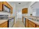 Galley kitchen featuring stainless steel appliances, wood cabinets and tiled flooring at 4897 Cypress Wood Dr # 6313, Orlando, FL 32811