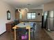 Open dining area with a modern light fixture and stainless steel refrigerator at 519 Spring Lake Rd, Ocala, FL 34472