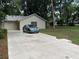 This home boasts a spacious driveway leading to an attached garage, complemented by a well-maintained lawn and classic architecture at 519 Spring Lake Rd, Ocala, FL 34472