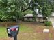 Quaint single-Gathering home featuring a lush front yard with mature trees, a mailbox, and a welcoming walkway at 519 Spring Lake Rd, Ocala, FL 34472