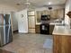 Functional kitchen with stainless steel appliances, tile floors, and wood cabinets at 519 Spring Lake Rd, Ocala, FL 34472