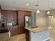 Gourmet kitchen with granite counters, stainless appliances and dark wood cabinets at 5255 Nw 33Rd Pl, Ocala, FL 34482