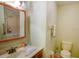 Cozy bathroom with wooden vanity, framed mirror, and ceramic tile flooring at 6190 Sw 84Th Pl, Ocala, FL 34476