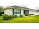 Well-maintained home with green shutters, a screened porch, and lush landscaping at 6190 Sw 84Th Pl, Ocala, FL 34476