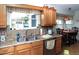 Bright kitchen features stainless steel sink, wood cabinets, and tiled backsplash and trim at 6190 Sw 84Th Pl, Ocala, FL 34476