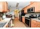 Modern kitchen featuring stainless steel appliances, granite countertops, and tile flooring at 6190 Sw 84Th Pl, Ocala, FL 34476