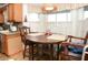 Eat-in kitchen features charming breakfast nook with wood cabinets, corner window, and wicker shade at 6190 Sw 84Th Pl, Ocala, FL 34476