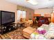 Comfortable living room features a large television, plush seating, and a bright window at 6190 Sw 84Th Pl, Ocala, FL 34476