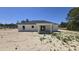 Rear exterior of a single-story house featuring a covered patio and ample yard space at 717 Marion Oaks Mnr, Ocala, FL 34473