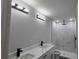 Modern bathroom with double vanity, marble shower, and sleek black fixtures at 717 Marion Oaks Mnr, Ocala, FL 34473
