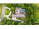 Stunning aerial view of a home, showcasing its unique roofline, screened pool, circular driveway, and lush landscaping at 7915 Se 12Th Cir, Ocala, FL 34480