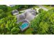 An aerial shot reveals a screened pool, unique roof and lush surroundings of this lovely home at 7915 Se 12Th Cir, Ocala, FL 34480