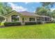 Lush green backyard, featuring a screened-in pool and well-maintained landscaping at 7915 Se 12Th Cir, Ocala, FL 34480