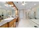 Large primary bathroom featuring a large vanity, walk-in shower, and separate soaking tub at 7915 Se 12Th Cir, Ocala, FL 34480