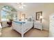 Bright bedroom with large window and vaulted ceiling featuring white furniture and hardwood floors at 7915 Se 12Th Cir, Ocala, FL 34480