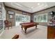 Spacious game room with a pool table, window, and sliding glass door to the outdoor pool at 7915 Se 12Th Cir, Ocala, FL 34480