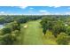 Scenic aerial view of a pristine golf course, highlighting lush green fairways and mature trees at 7915 Se 12Th Cir, Ocala, FL 34480