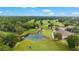 Panoramic view of a lush golf course with a pond, mature trees, and meticulously manicured greens at 7915 Se 12Th Cir, Ocala, FL 34480