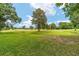 Expansive green golf course view featuring mature trees under a bright blue sky with scattered clouds at 7915 Se 12Th Cir, Ocala, FL 34480