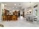 Open kitchen and dining area with tile floors, island with seating, and modern lighting at 7915 Se 12Th Cir, Ocala, FL 34480