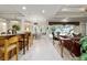 Open-concept living space featuring tile flooring, kitchen bar, and outdoor pool view at 7915 Se 12Th Cir, Ocala, FL 34480