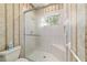 Shower area featuring glass doors, tiled walls, seating, and a window at 7915 Se 12Th Cir, Ocala, FL 34480