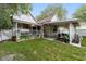 Charming home's backyard features a covered patio, lush lawn, and a white picket fence for added privacy at 828 Se 3Rd St, Ocala, FL 34471