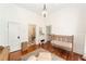 Bedroom with hardwood floors, neutral tones, and an open doorway to an adjacent room at 828 Se 3Rd St, Ocala, FL 34471