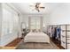 Sunlit bedroom with hardwood floors, neutral walls, ceiling fan, and well-lit windows at 828 Se 3Rd St, Ocala, FL 34471