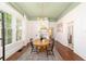 Dining room area with a round table, vintage area rug, green ceiling accents, fireplace, and hardwood floors at 828 Se 3Rd St, Ocala, FL 34471