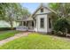 Charming home with a brick pathway leading to a cozy porch, complemented by lush greenery and inviting curb appeal at 828 Se 3Rd St, Ocala, FL 34471