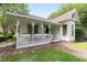 Charming porch with ornate columns, a decorative swing, and flower boxes, perfect for relaxing and enjoying the outdoors at 828 Se 3Rd St, Ocala, FL 34471