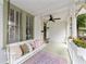 Cozy porch with swing, ceiling fan, and decorative pillows perfect for relaxing outdoors at 828 Se 3Rd St, Ocala, FL 34471