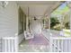 Inviting front porch features a comfortable swing, ceiling fan, and colorful flower boxes, creating a serene outdoor space at 828 Se 3Rd St, Ocala, FL 34471