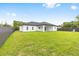 Exterior view of the back of the house with a well-manicured lawn and fence at 8456 Se 164Th Pl, Summerfield, FL 34491