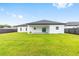 Spacious backyard with green grass and a modern home exterior at 8456 Se 164Th Pl, Summerfield, FL 34491