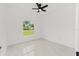 Bright bedroom featuring tile floors, ceiling fan, and a view of the yard at 8456 Se 164Th Pl, Summerfield, FL 34491