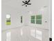 Bright bedroom with white tile floors, multiple windows offering natural light, and a modern ceiling fan at 8456 Se 164Th Pl, Summerfield, FL 34491