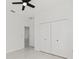 Bright bedroom with white walls, tile floors, and a modern ceiling fan and closet at 8456 Se 164Th Pl, Summerfield, FL 34491